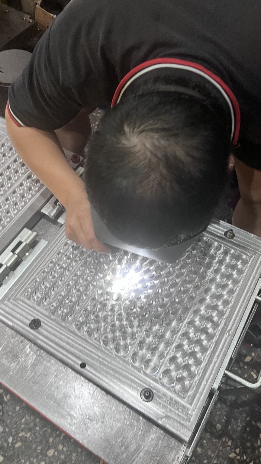 人員近距離檢查模具表面